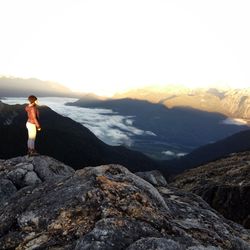 Man looking at mountain against sky