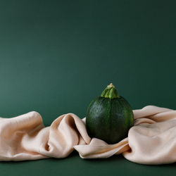 Close-up of hand holding fruit over white background