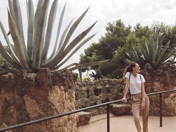 Woman standing by tree against sky