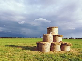 Scenic view of field against cloudy sky