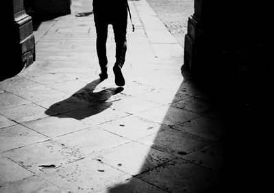 Low section of man walking on street