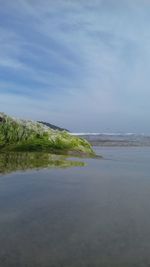 Scenic view of calm lake against cloudy sky