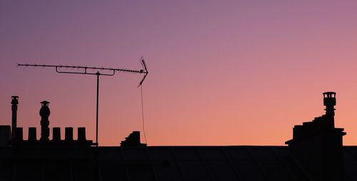 Silhouette communications tower against sky during sunset