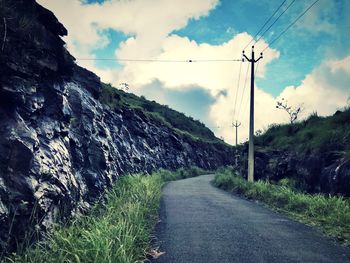 Road by mountain against sky