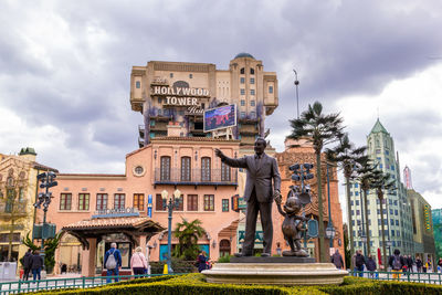 Statue against building in city against sky