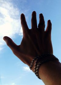 Low angle view of cropped hand against clear sky