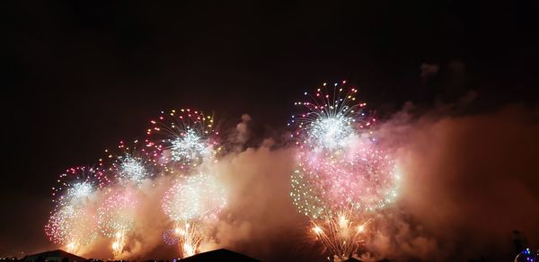 Low angle view of firework display at night