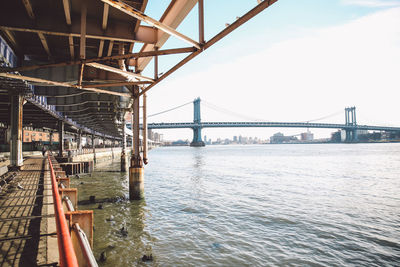 Manhattan bridge over east river against sky seen from walkway