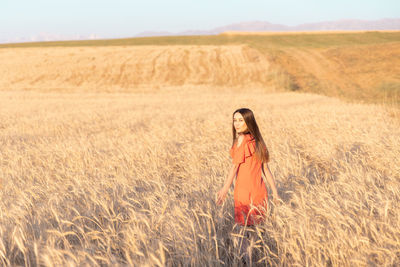 Young woman in the wheat field. look back. finding inner balance concept. copy space