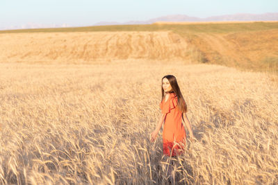 Rear view of woman standing on field