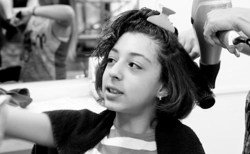 Midsection of mother drying daughter hair at home