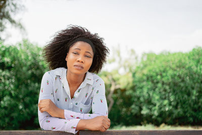 Woman with a thoughtful expression and looking serious while standing outdoors.