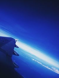 Airplane flying over sea against blue sky