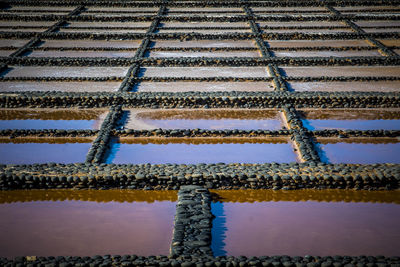 View on traditional rectangular salt evaporation ponds or salt pans creating a grid 