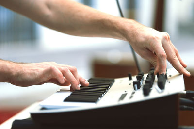 Cropped hand of man playing piano