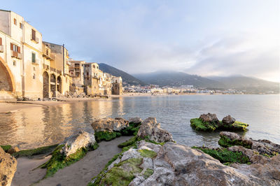 View of buildings by sea against sky