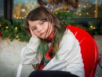 Portrait of girl siting on chair at home