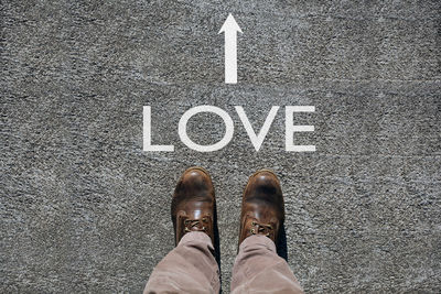 Low section of man standing on road