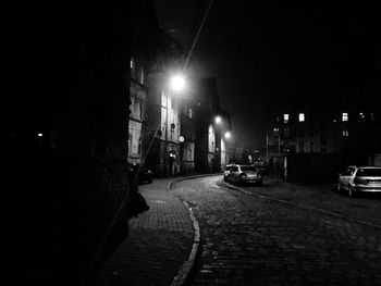 Street amidst illuminated buildings in city at night