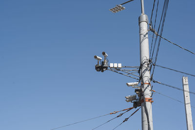 Low angle view of electricity pylon against clear sky