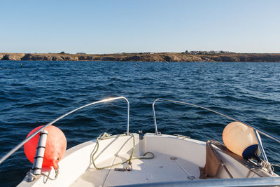 Boat sailing in sea against clear sky