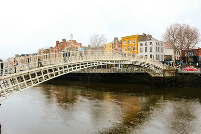 Bridge over river against buildings in city