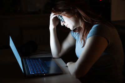 Depressed woman with laptop at home