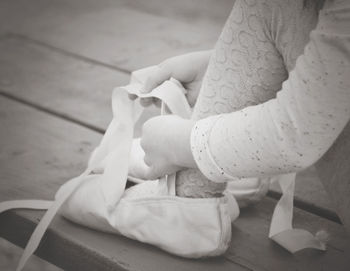 Low section of woman holding umbrella on hardwood floor