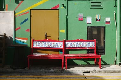 Empty chairs and tables against building