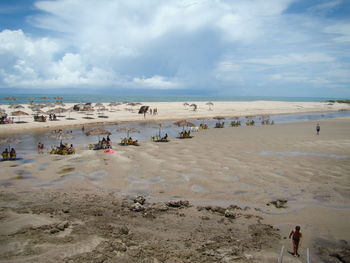 People on beach against sky
