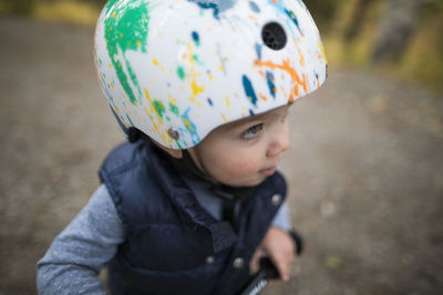 Cute baby boy wearing bicycle helmet while looking away