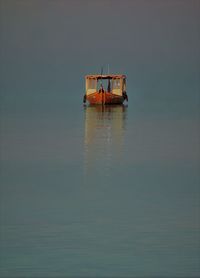 Boat moored on sea against sky