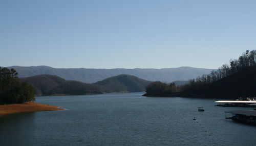 Scenic view of lake and mountains against clear sky