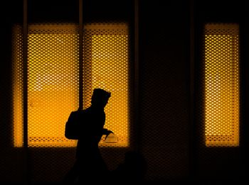 Silhouette people standing against window