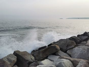 Scenic view of rocks in sea against sky