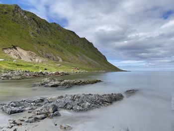 Scenic view of ocean against sky and mountain