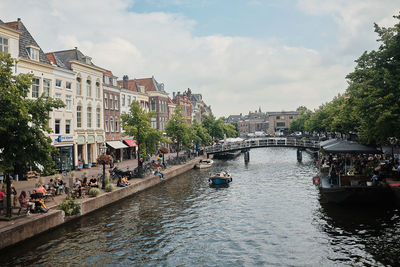 Bridge over river in city against sky