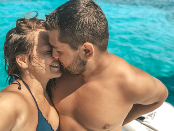 Portrait of young couple kissing in swimming pool