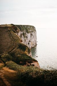 Rock formations by sea against sky