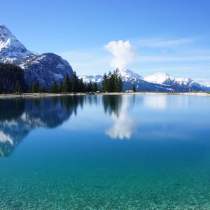 Scenic view of lake and snowcapped mountains against sky