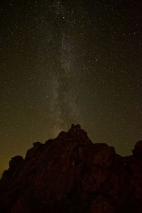 Low angle view of rock formation against sky at night