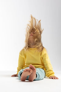 Side view of woman sitting on bed at home