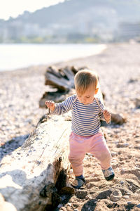 Full length of cute boy on rock