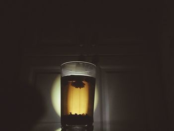 Close-up of lit candle in darkroom