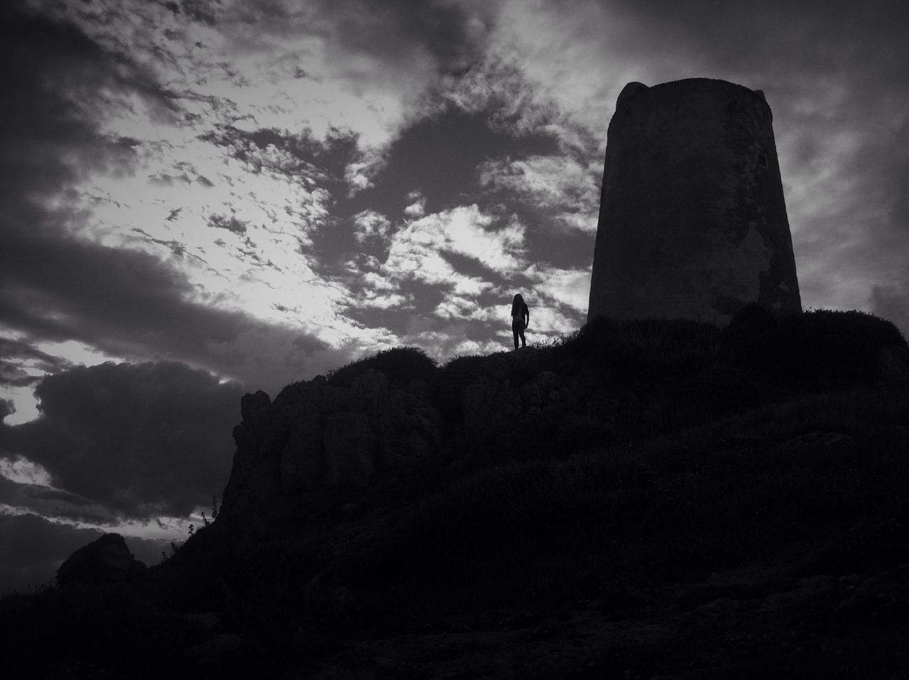 sky, cloud - sky, low angle view, rock - object, cloudy, rock formation, history, silhouette, tranquility, tranquil scene, nature, cloud, famous place, scenics, cliff, travel destinations, landscape, built structure, mountain, travel