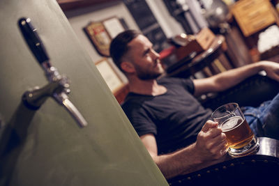 Midsection of man drinking glass