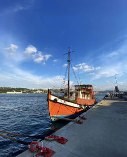 Sailboats moored on sea against sky