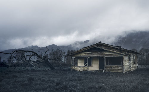 Abandoned house on mountain against sky