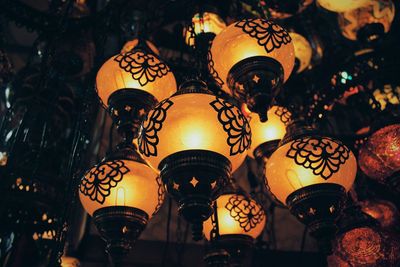 Low angle view of illuminated lanterns hanging in store