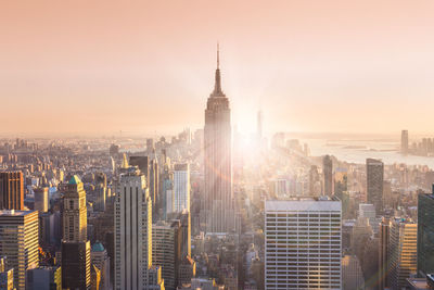 Aerial view of buildings in city at sunset
